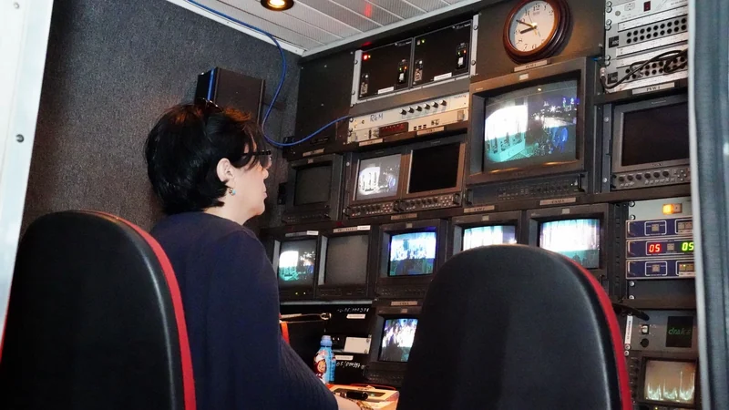 A television gallery with a wall of monitors and a vision mixing desk, racing graphics queued on the preview row.